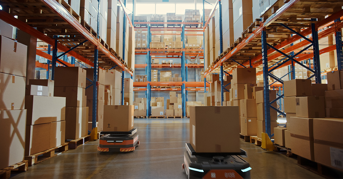 autonomous-mobile-robots-transporting-cartons-through-rack-aisle-in-warehouse-robotics