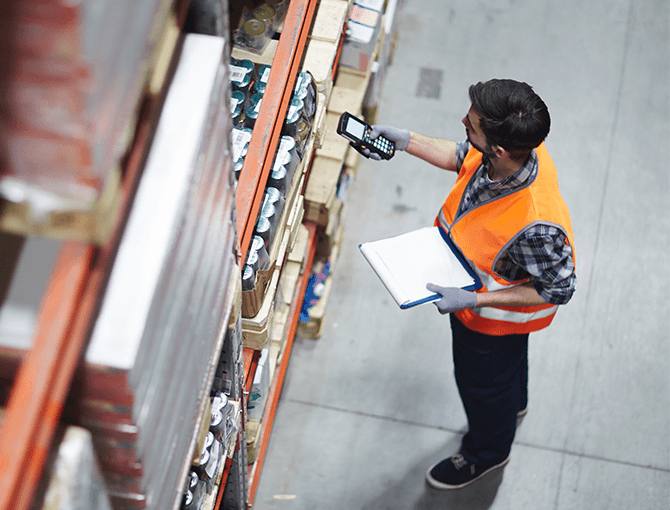 warehouse worker using RF scan technology on inventory