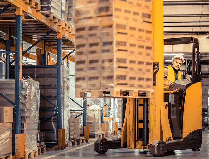 warehouse gig worker operating a forklift carrying pallets
