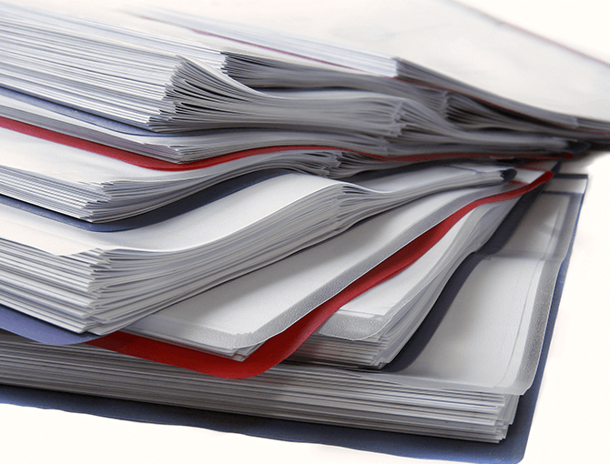 Stack of paper reports representing manual warehouse with paper-based reporting prior to warehouse software