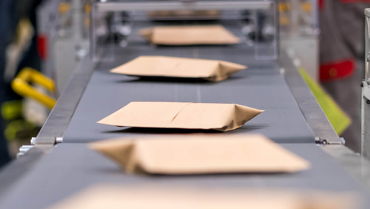 mailer packages traveling on conveyor belt