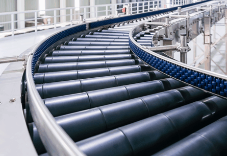 Curved conveyor belt with black rollers in a clean, modern warehouse - FORTNA